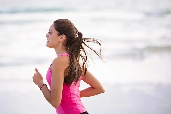 Solo female runner jogging on beach